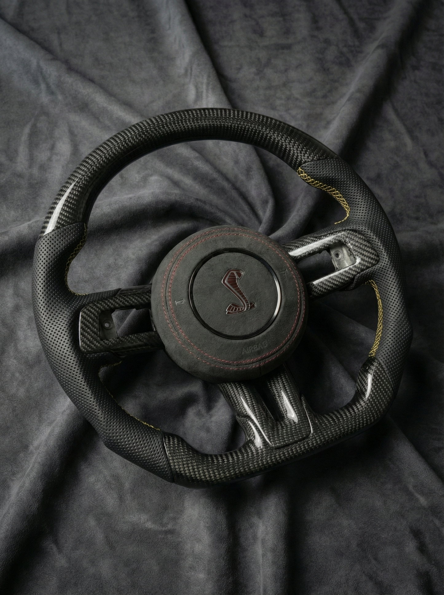 Steering wheel with a logo on a dark fabric background
