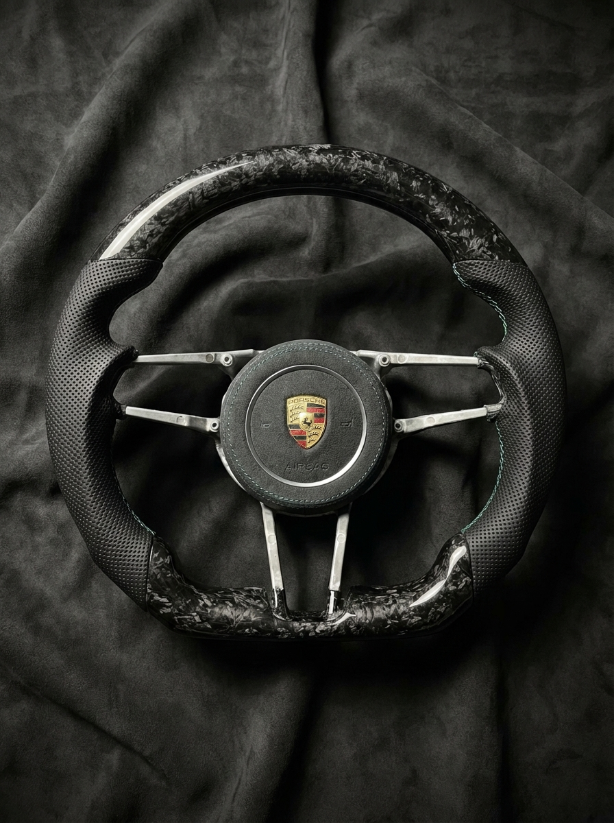Steering wheel with Porsche logo on a dark fabric background