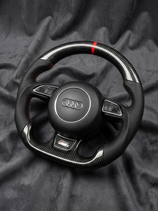 Carbon fiber steering wheel with Audi logo on a dark fabric background