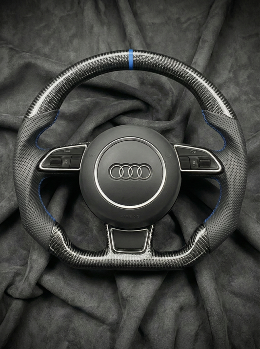 Steering wheel with Audi logo on a dark fabric background