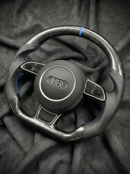 Steering wheel with Audi logo on a dark fabric background