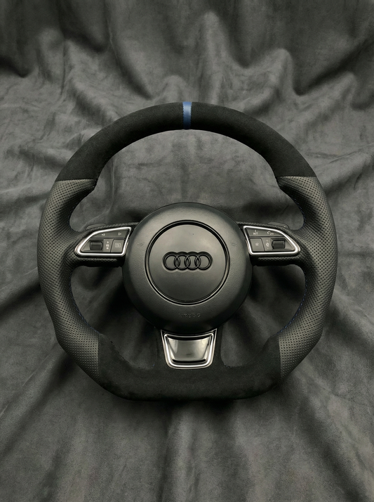 Black Audi steering wheel on a gray fabric background