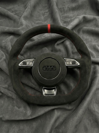 Black Audi steering wheel on a gray fabric background