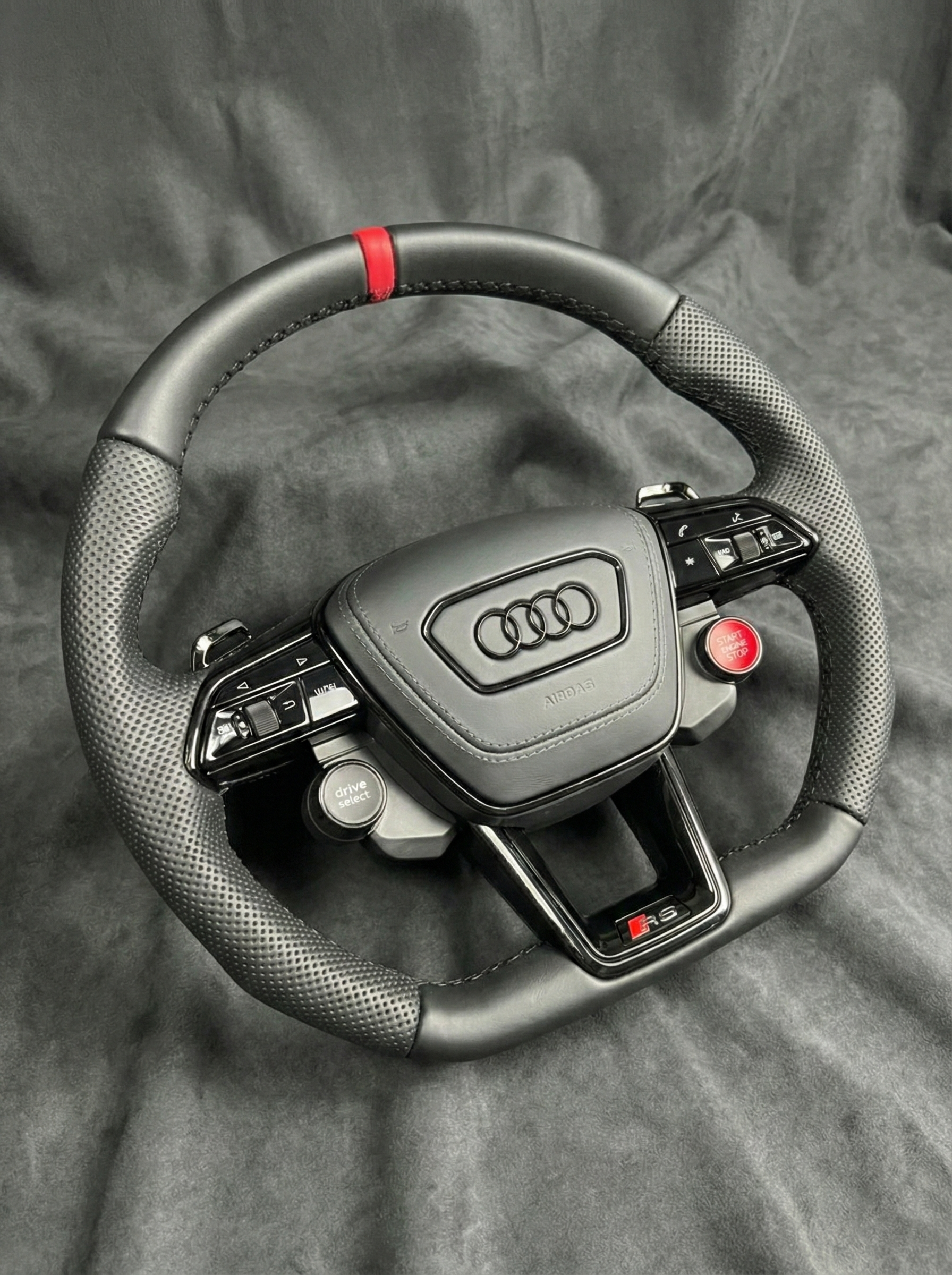 Steering wheel with Audi logo on a gray background
