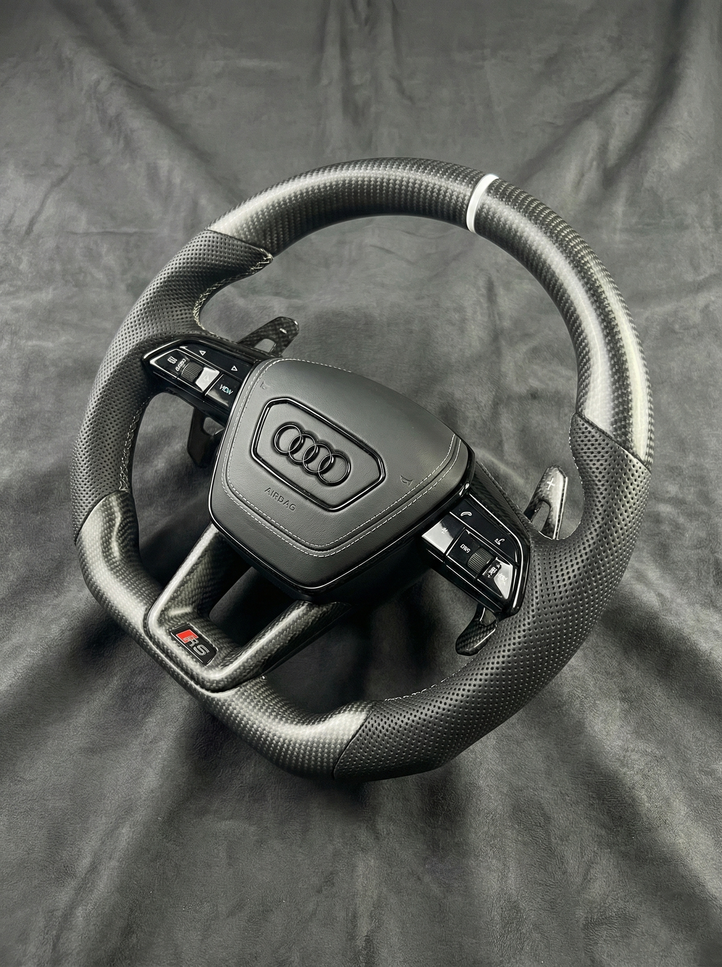 Steering wheel with Audi logo on a gray background