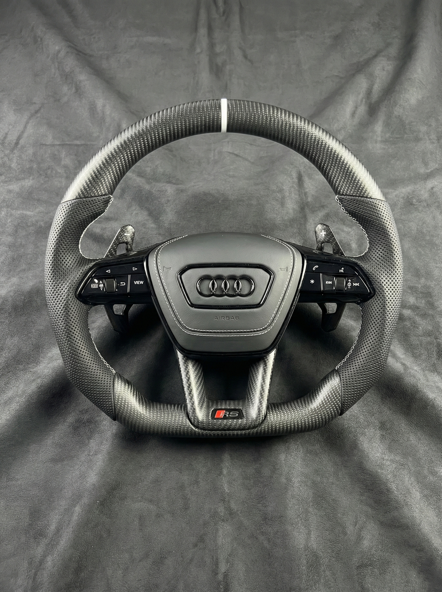 Car steering wheel with Audi logo on a gray background