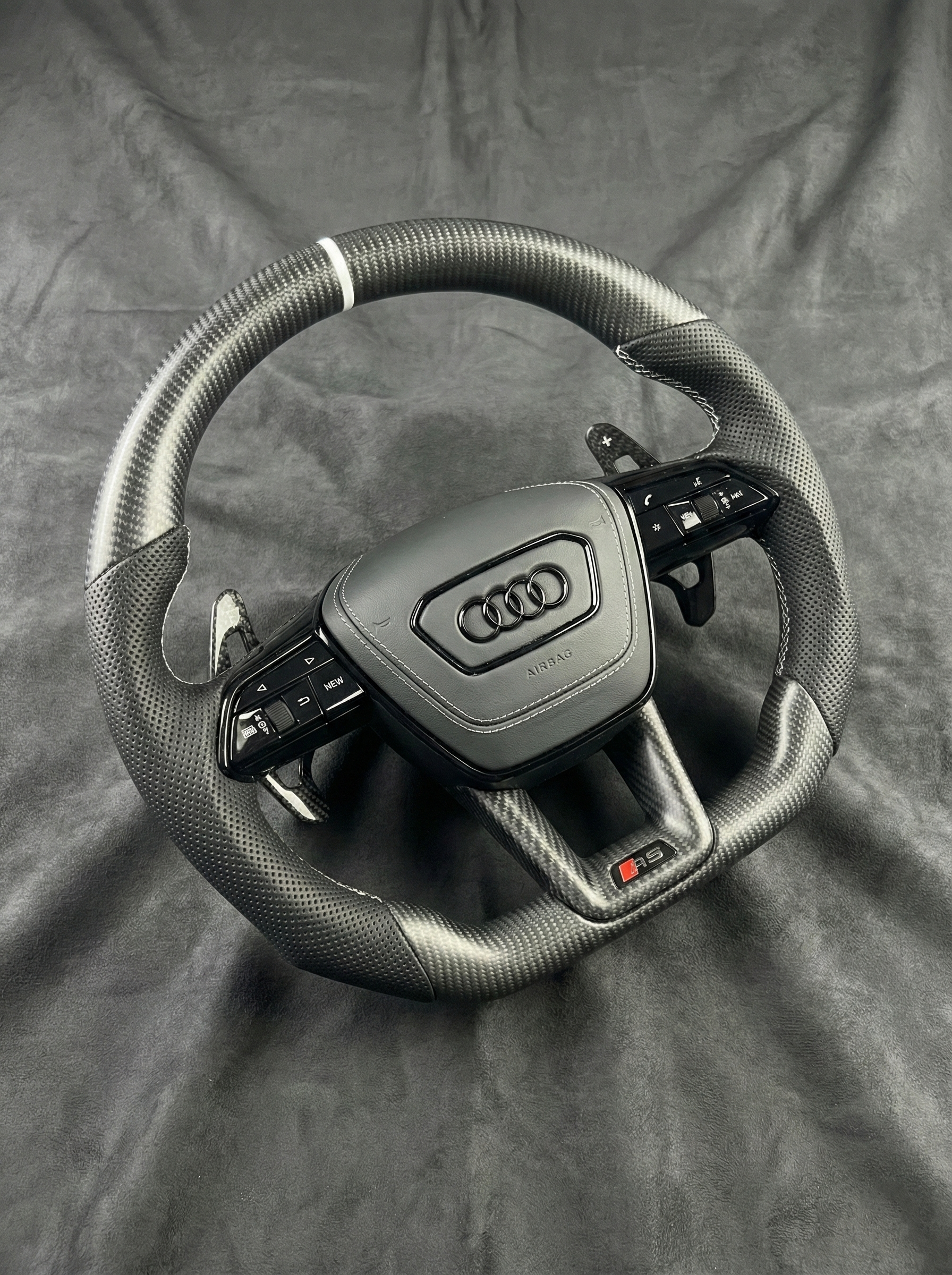 Steering wheel with Audi logo on a gray background