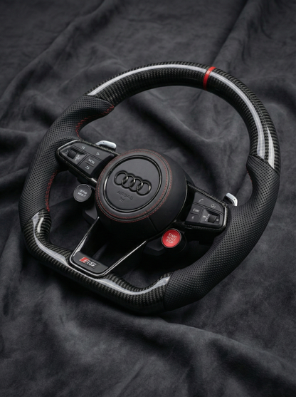 Black Audi steering wheel on a dark fabric background