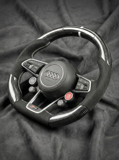 Steering wheel with Audi logo on a dark fabric background