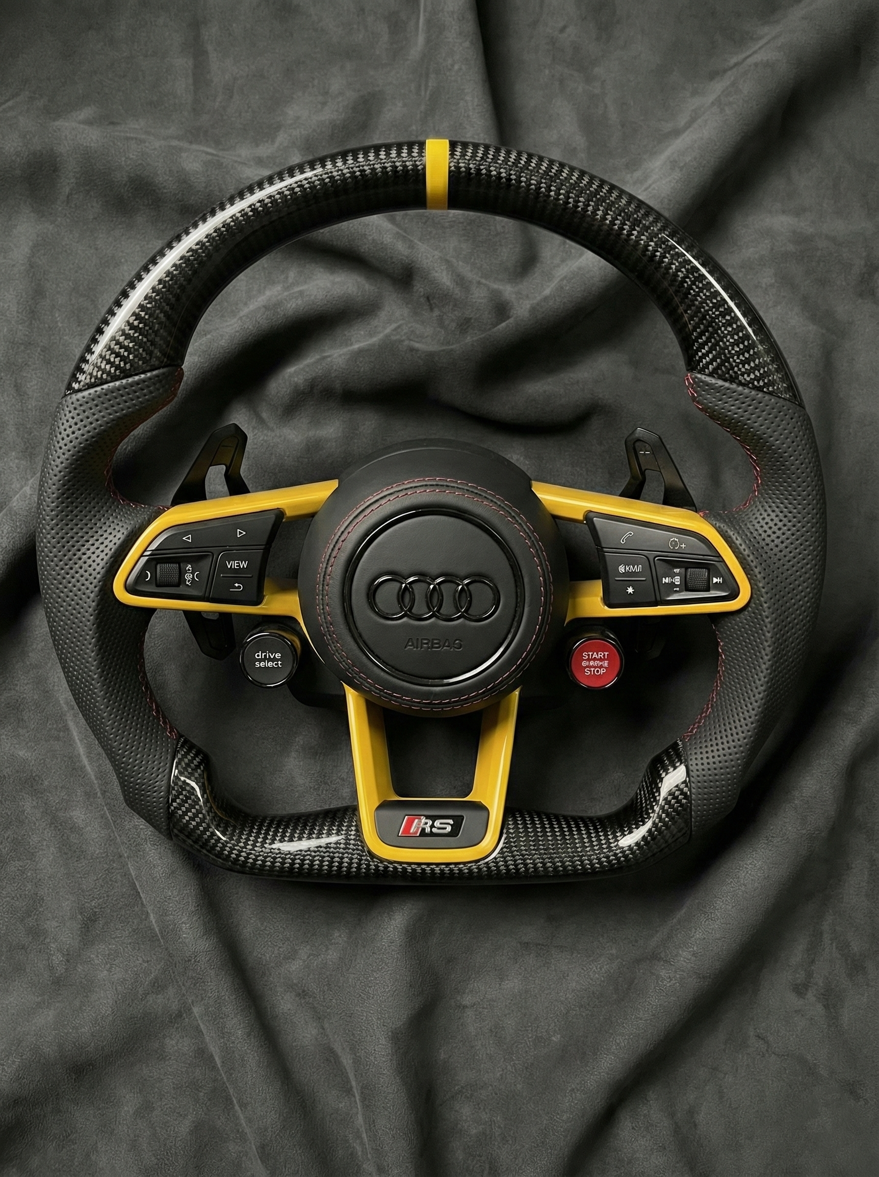 Audi steering wheel with yellow accents on a dark background
