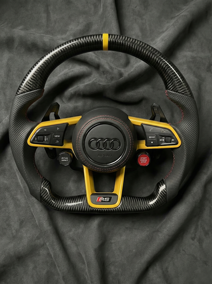 Audi steering wheel with yellow accents on a dark background
