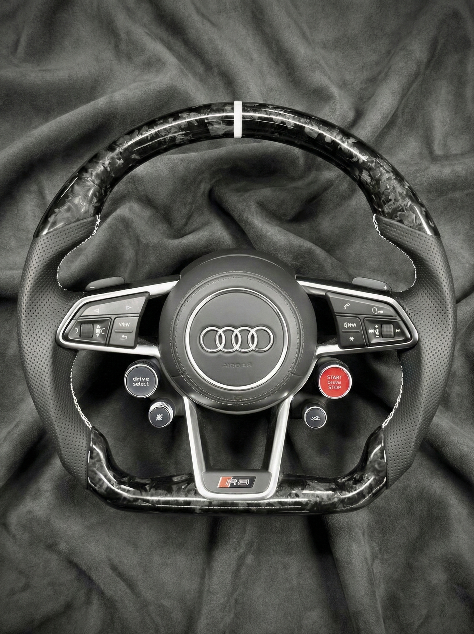 Steering wheel with Audi logo on a textured surface