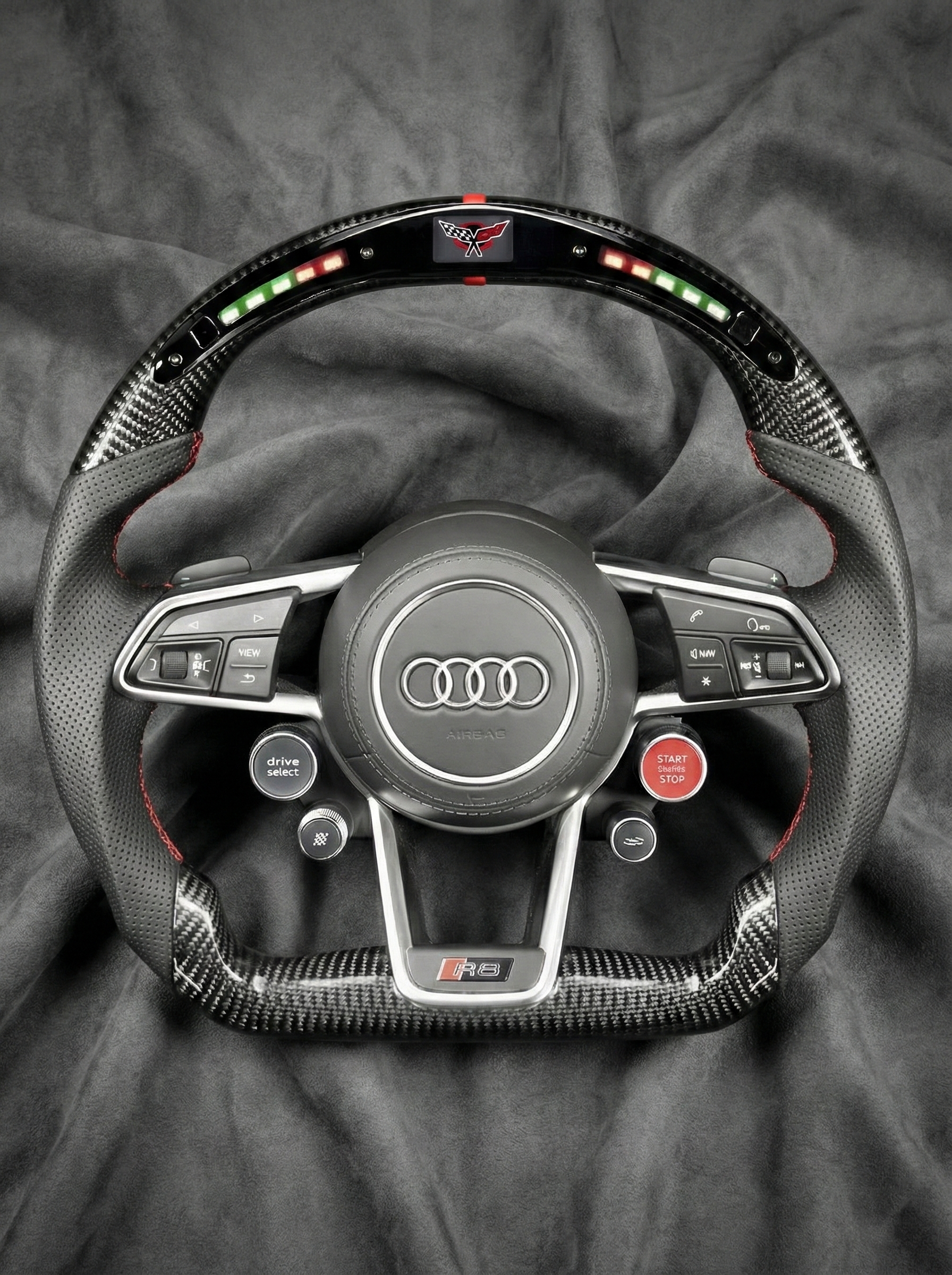 Car steering wheel with Audi logo on a gray fabric background