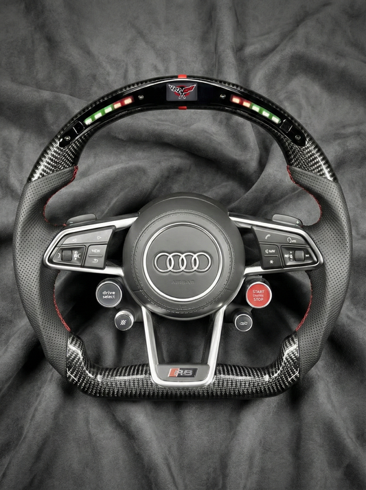 Car steering wheel with Audi logo on a gray fabric background