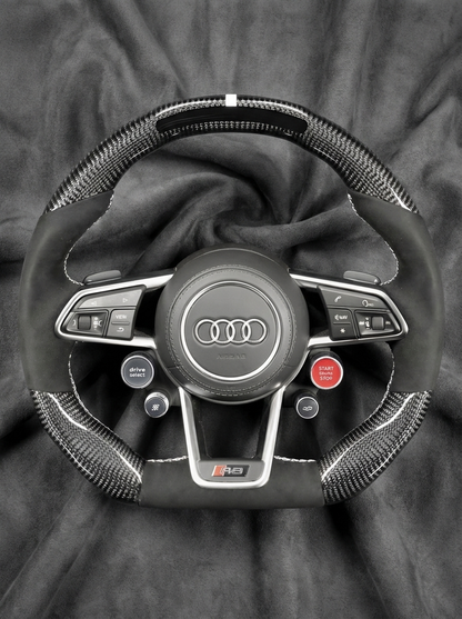 Steering wheel with Audi logo on a dark background