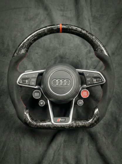 Carbon fiber steering wheel with Audi logo on a dark background