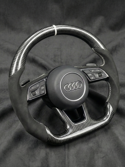 Steering wheel with Audi logo on a dark background
