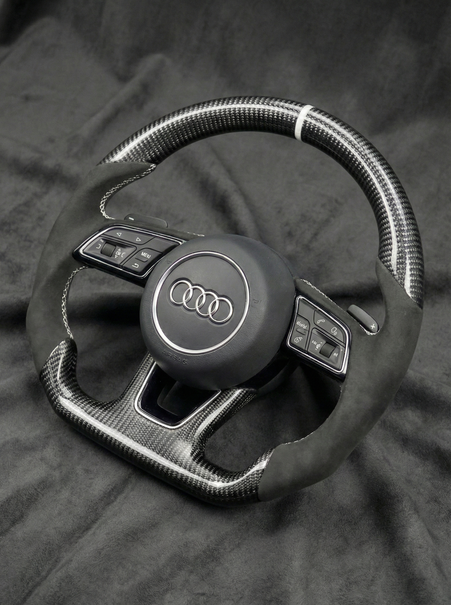 Steering wheel with Audi logo on a dark background