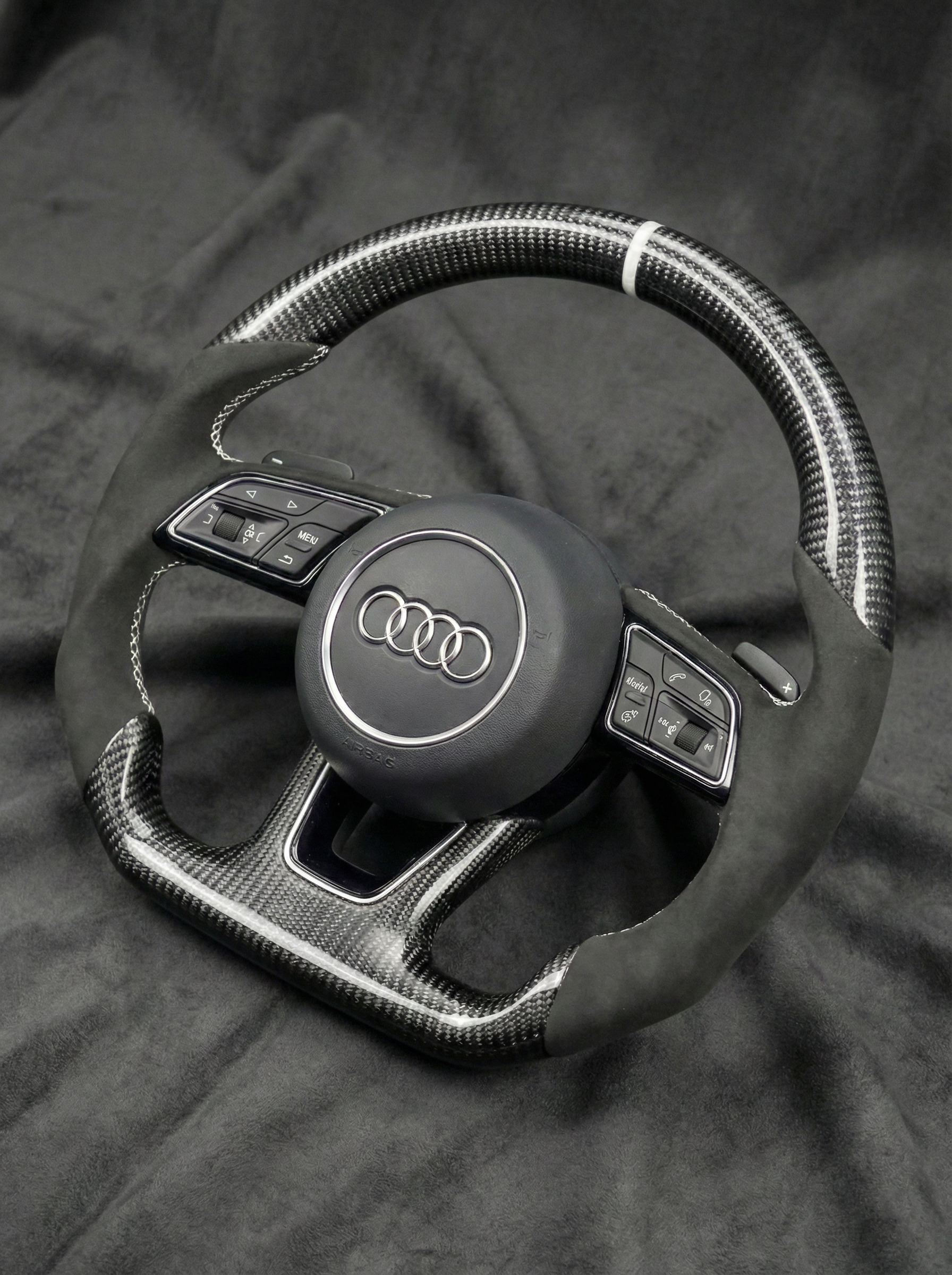 Steering wheel with Audi logo on a dark background
