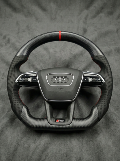 Carbon fiber steering wheel with Audi logo on a gray background