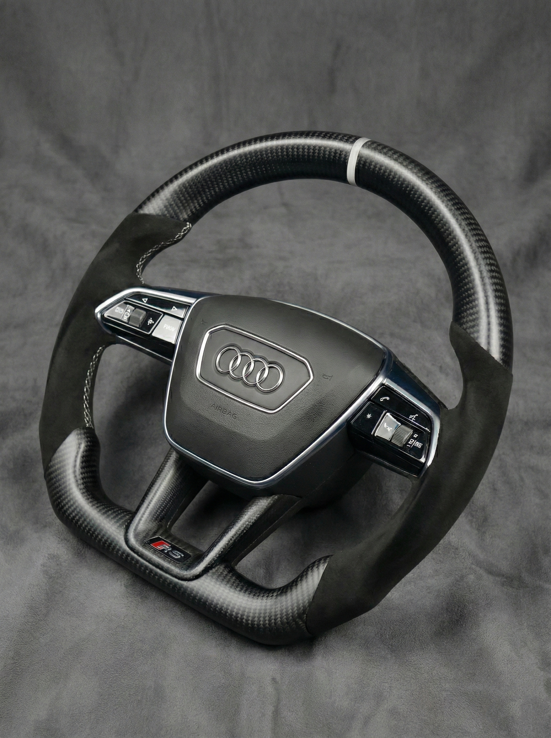 Steering wheel with Audi logo on a gray background