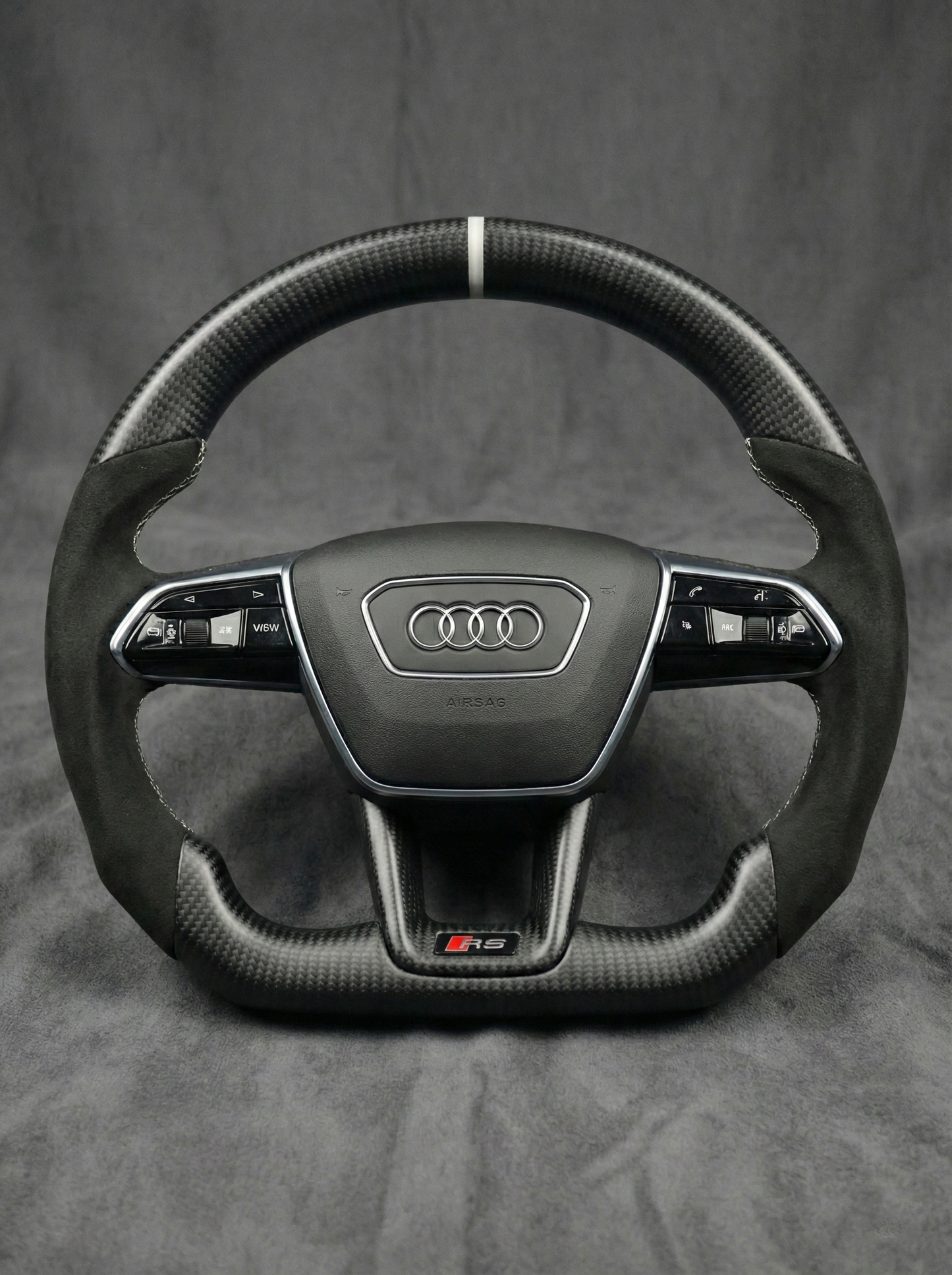 Carbon fiber steering wheel with Audi logo on a gray background