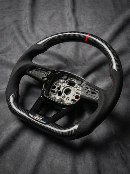 Carbon fiber steering wheel with silver center on a dark fabric background