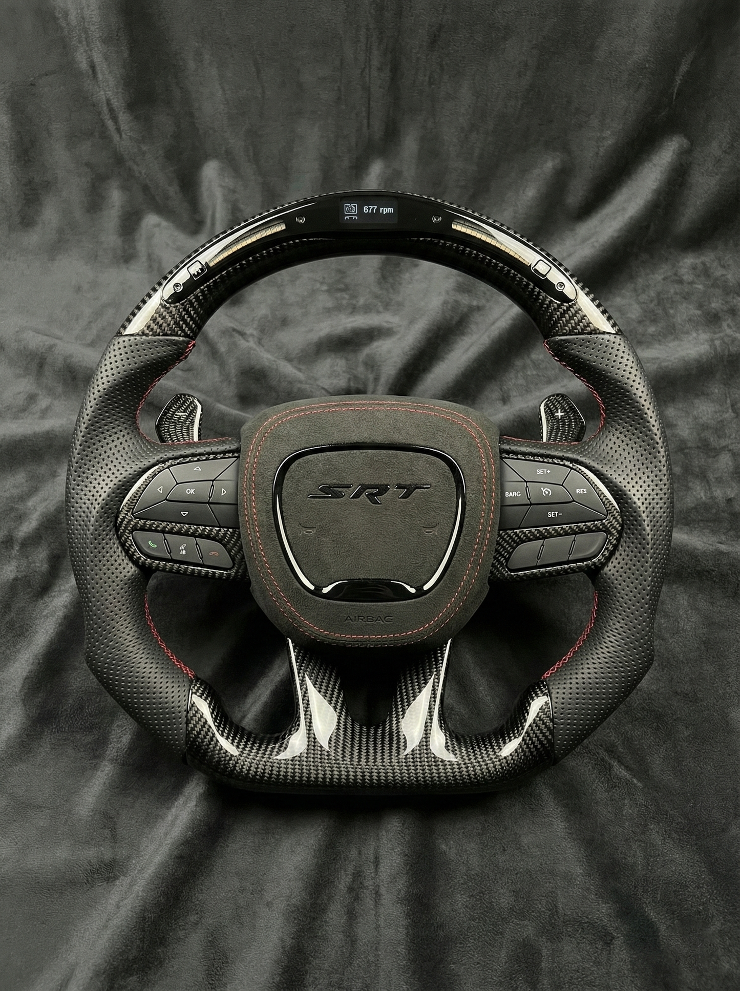 Steering wheel with SRT logo on a dark fabric background