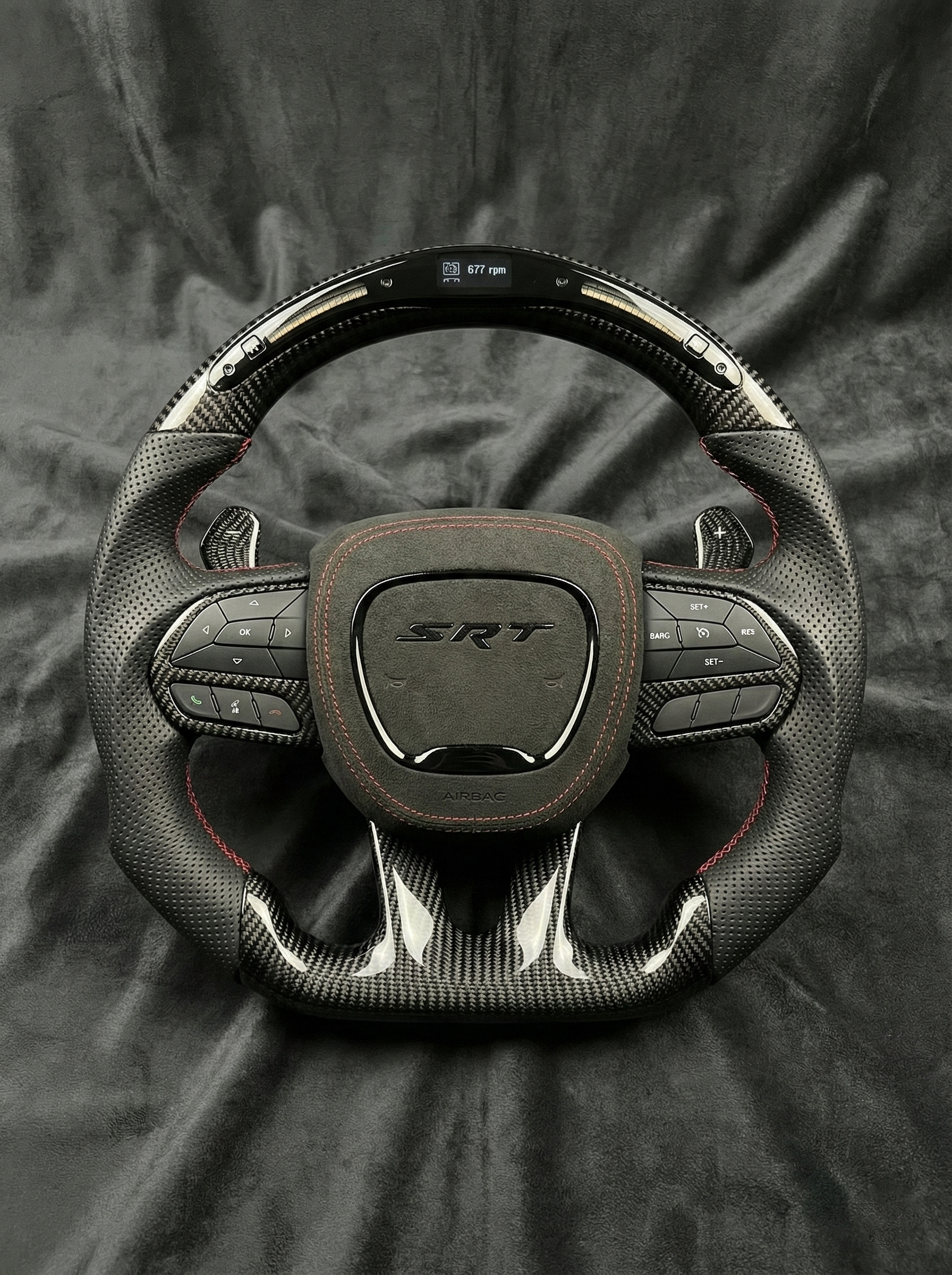 Steering wheel with SRT logo on a dark fabric background