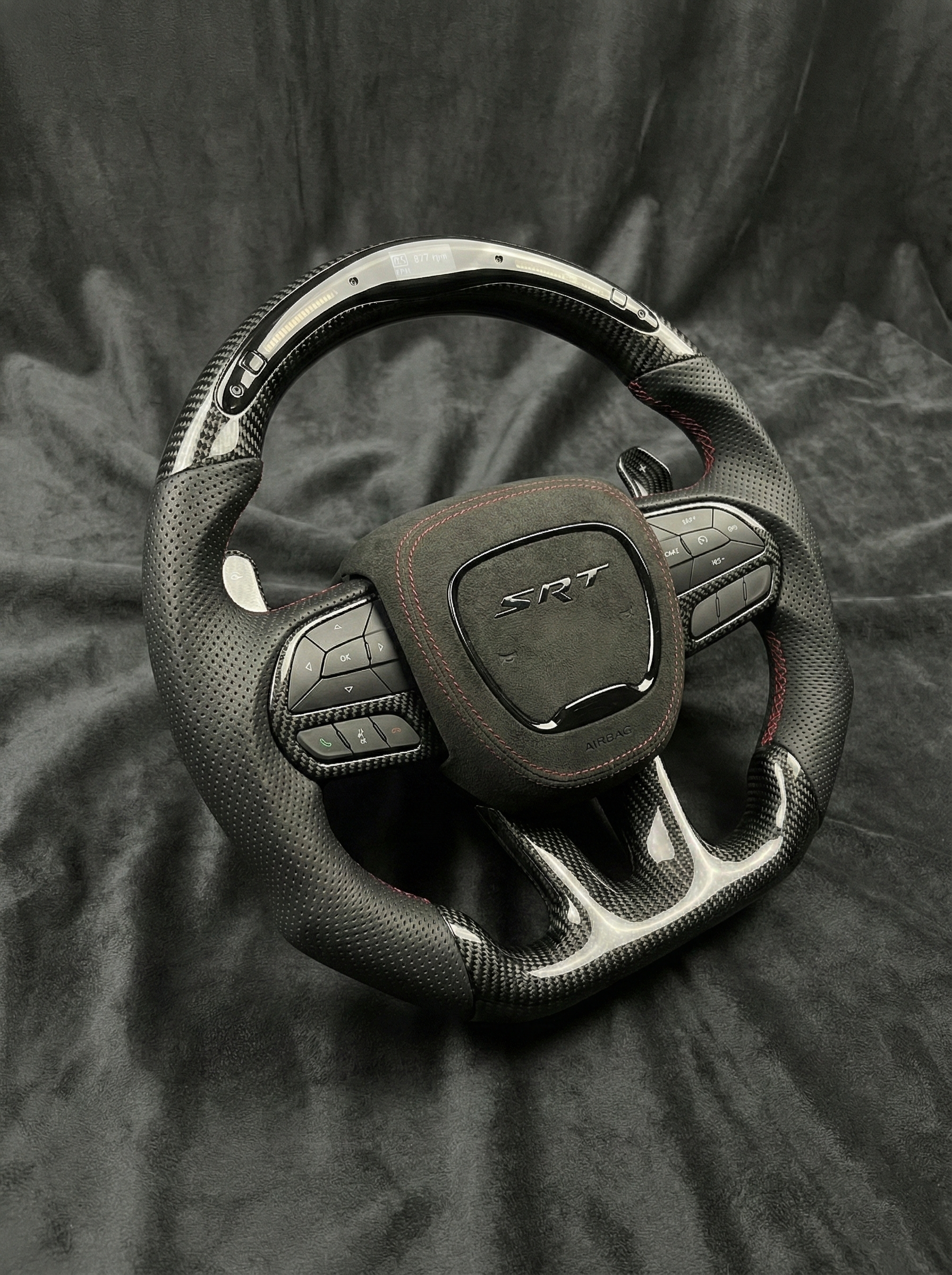 Car steering wheel with SRT logo on a dark fabric background