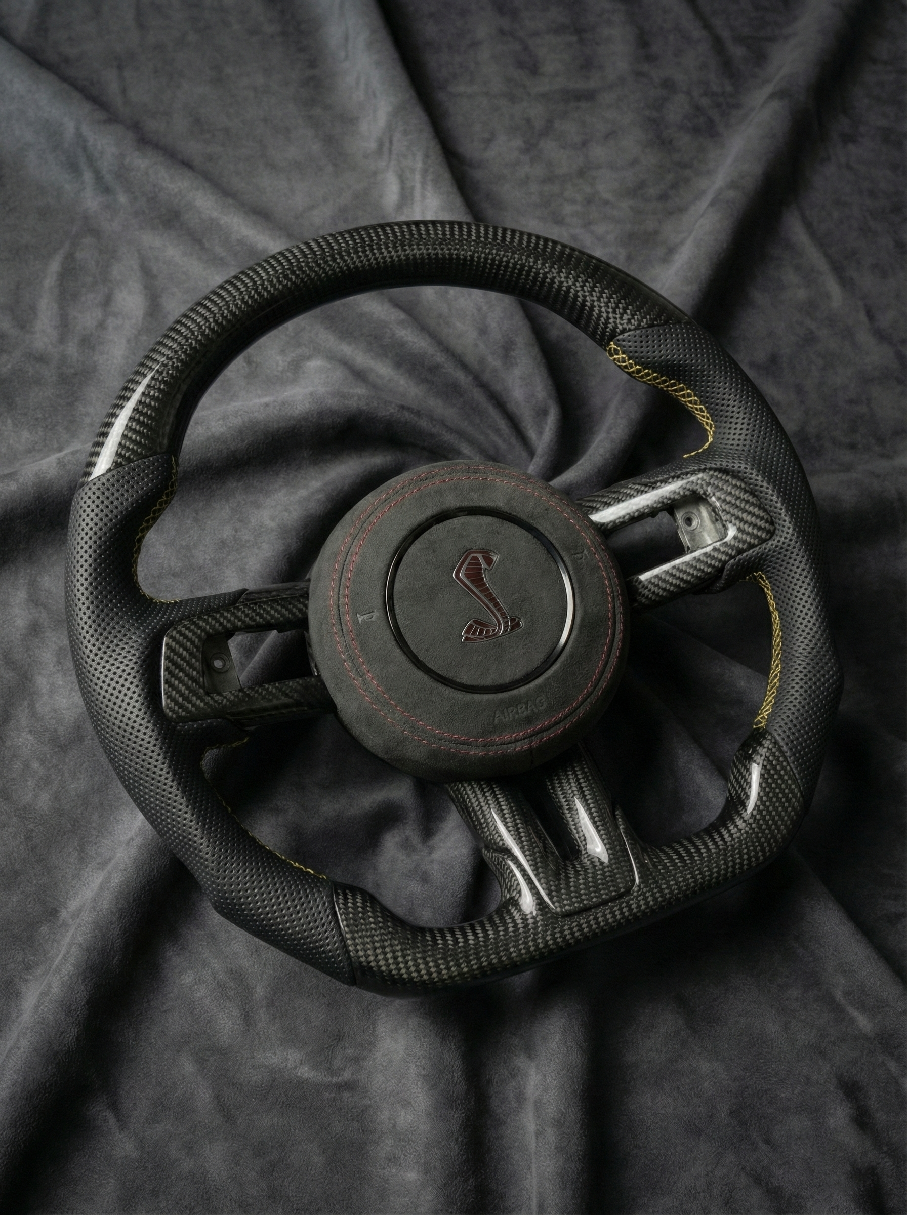Steering wheel with a logo on a dark fabric background