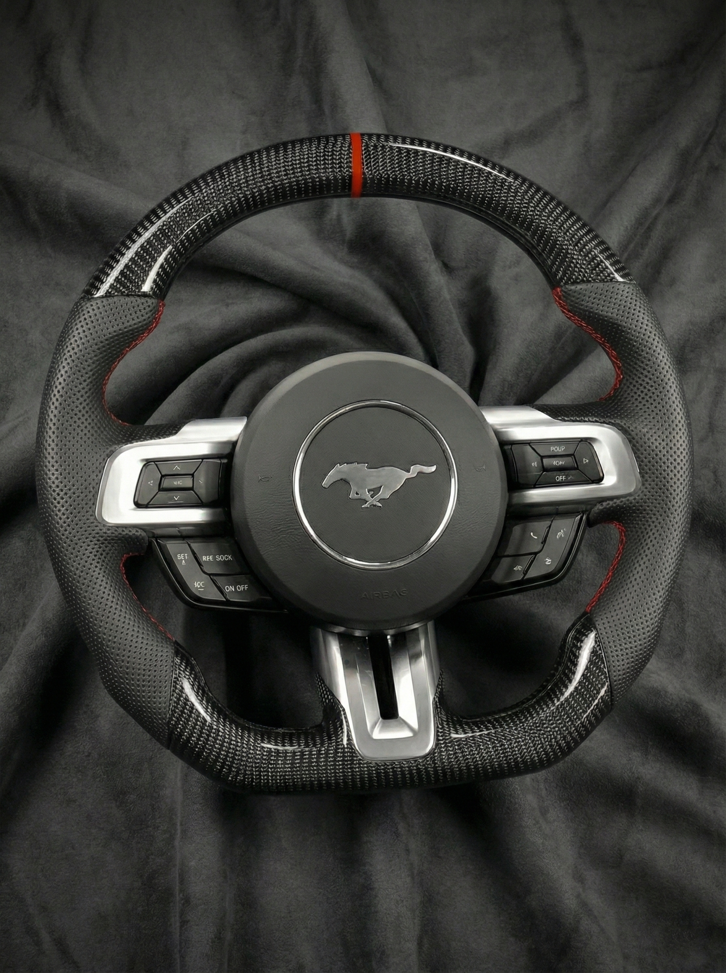 Steering wheel with Mustang logo on a dark fabric background