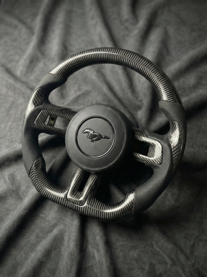 Steering wheel with Mustang logo on a dark fabric background