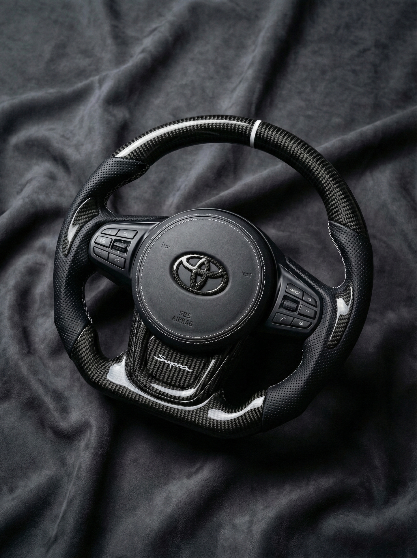 Steering wheel with Toyota logo on a dark fabric background