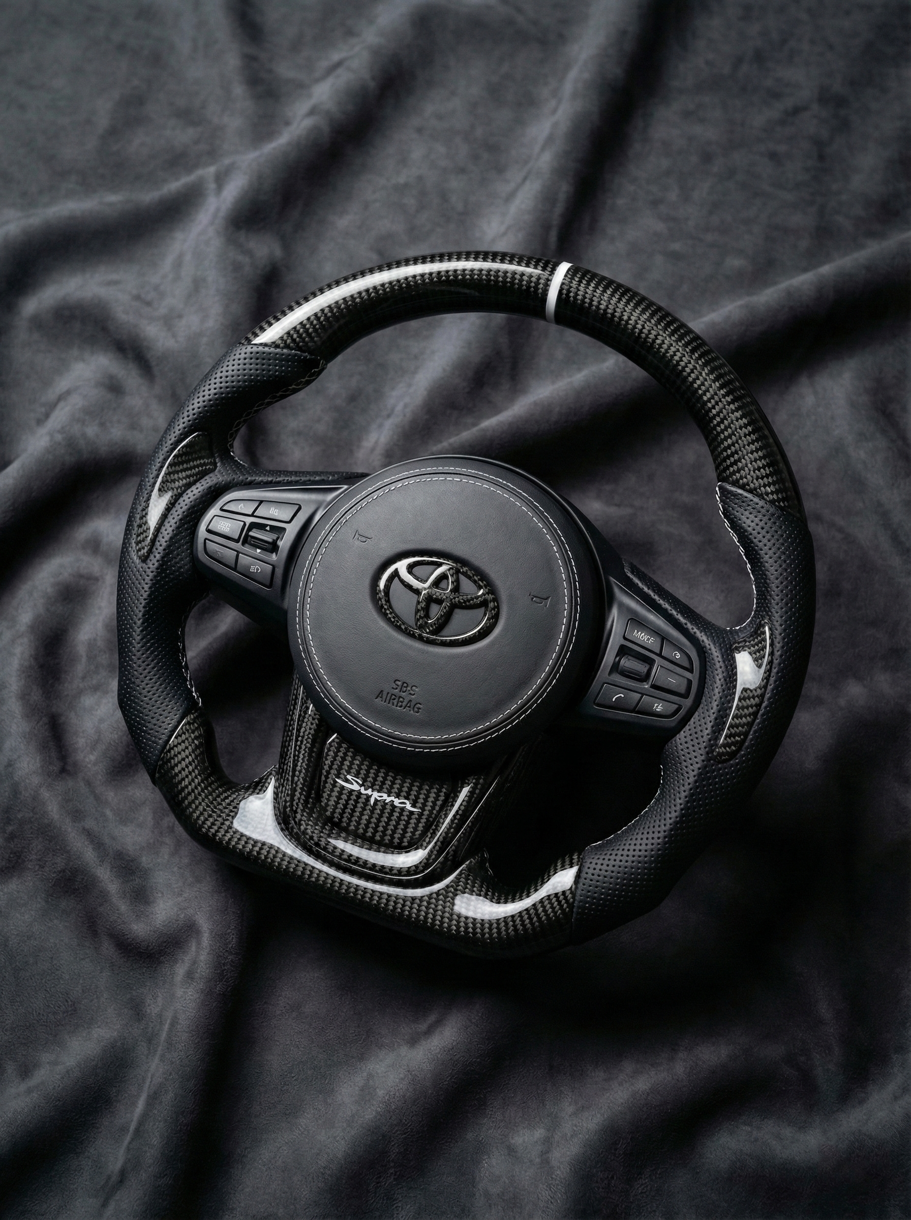 Steering wheel with Toyota logo on a dark fabric background