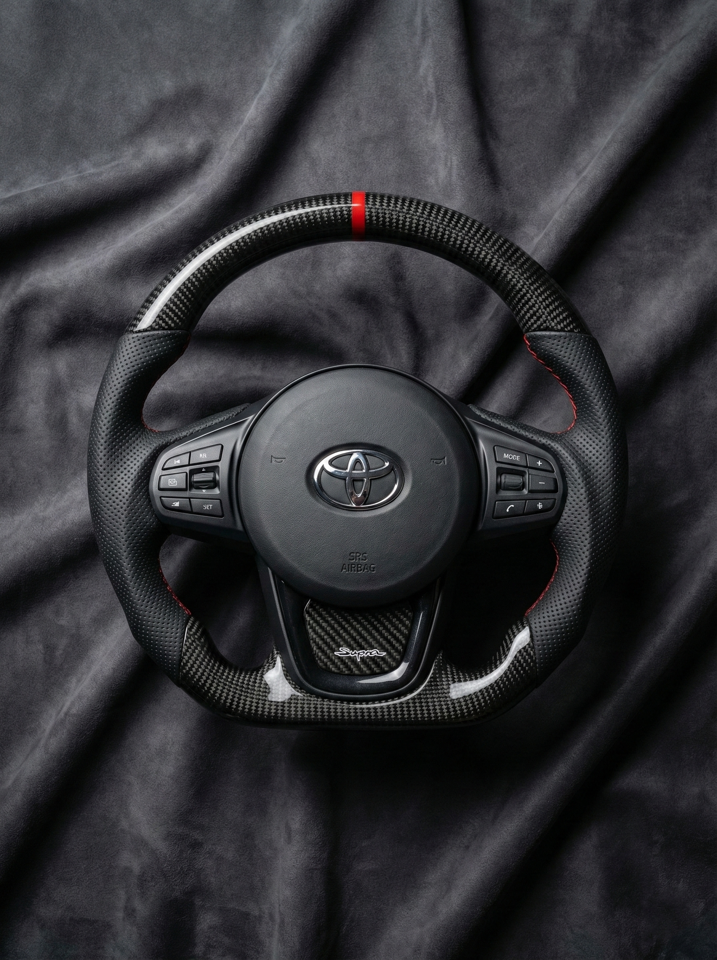 Steering wheel with Toyota logo on a dark fabric background