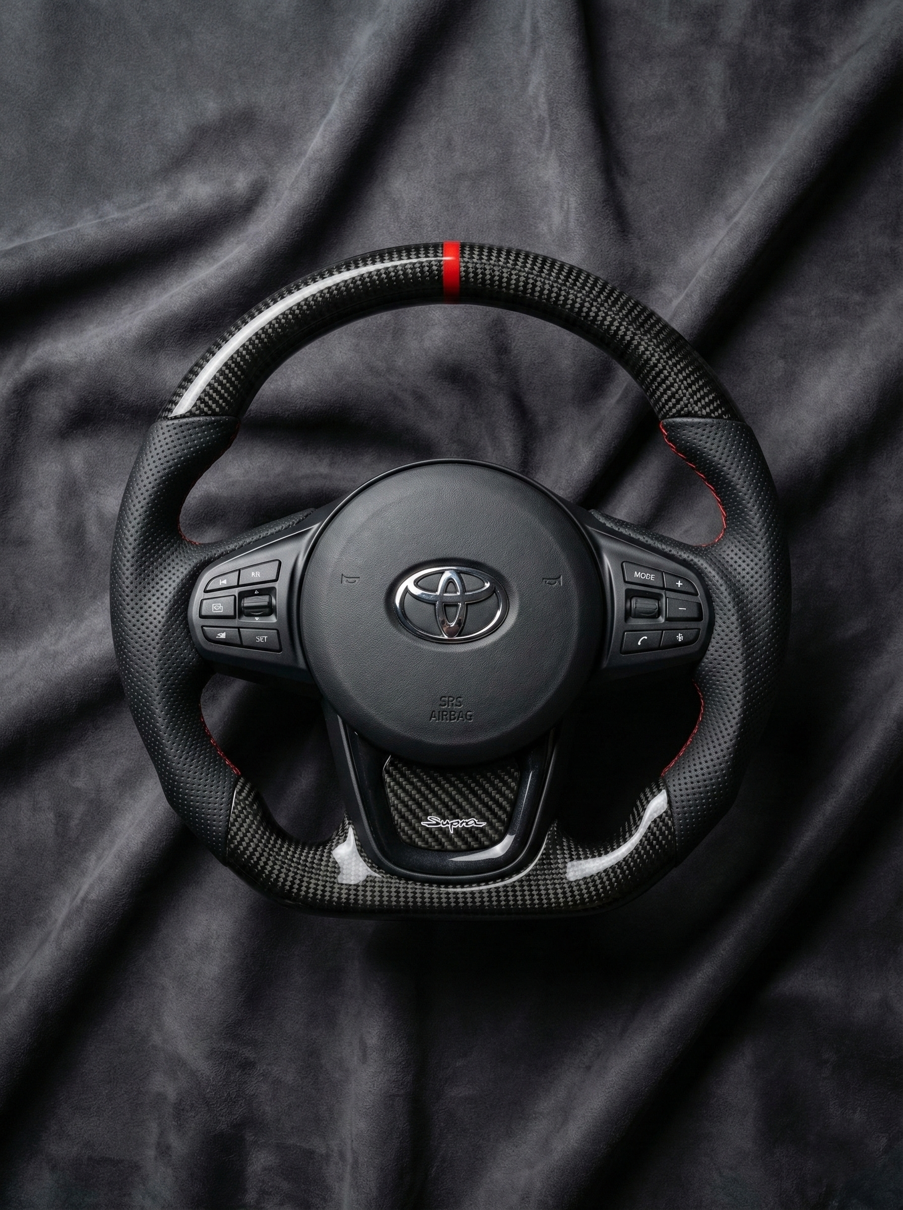 Steering wheel with Toyota logo on a dark fabric background