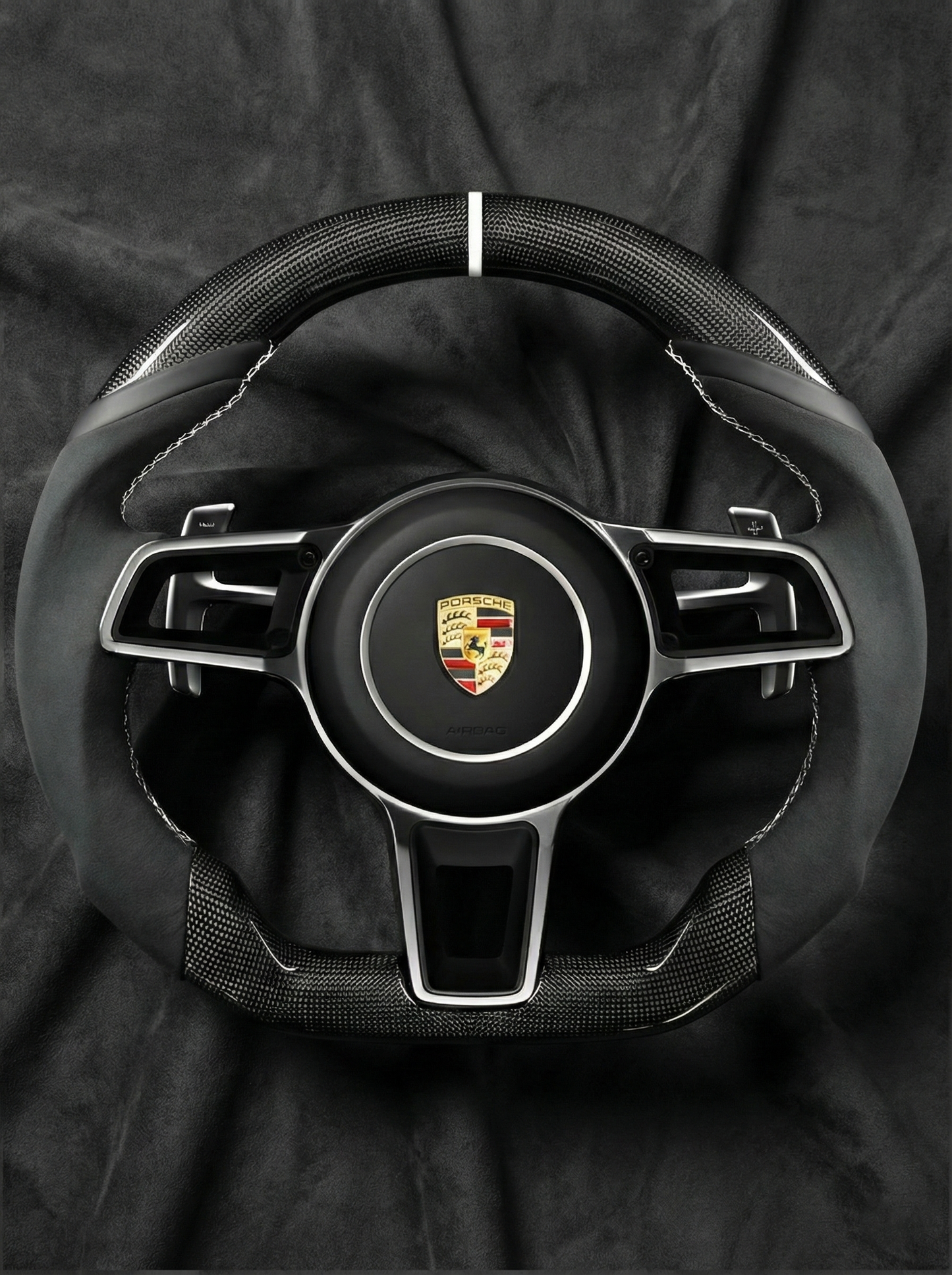 Steering wheel with Porsche logo on a black background