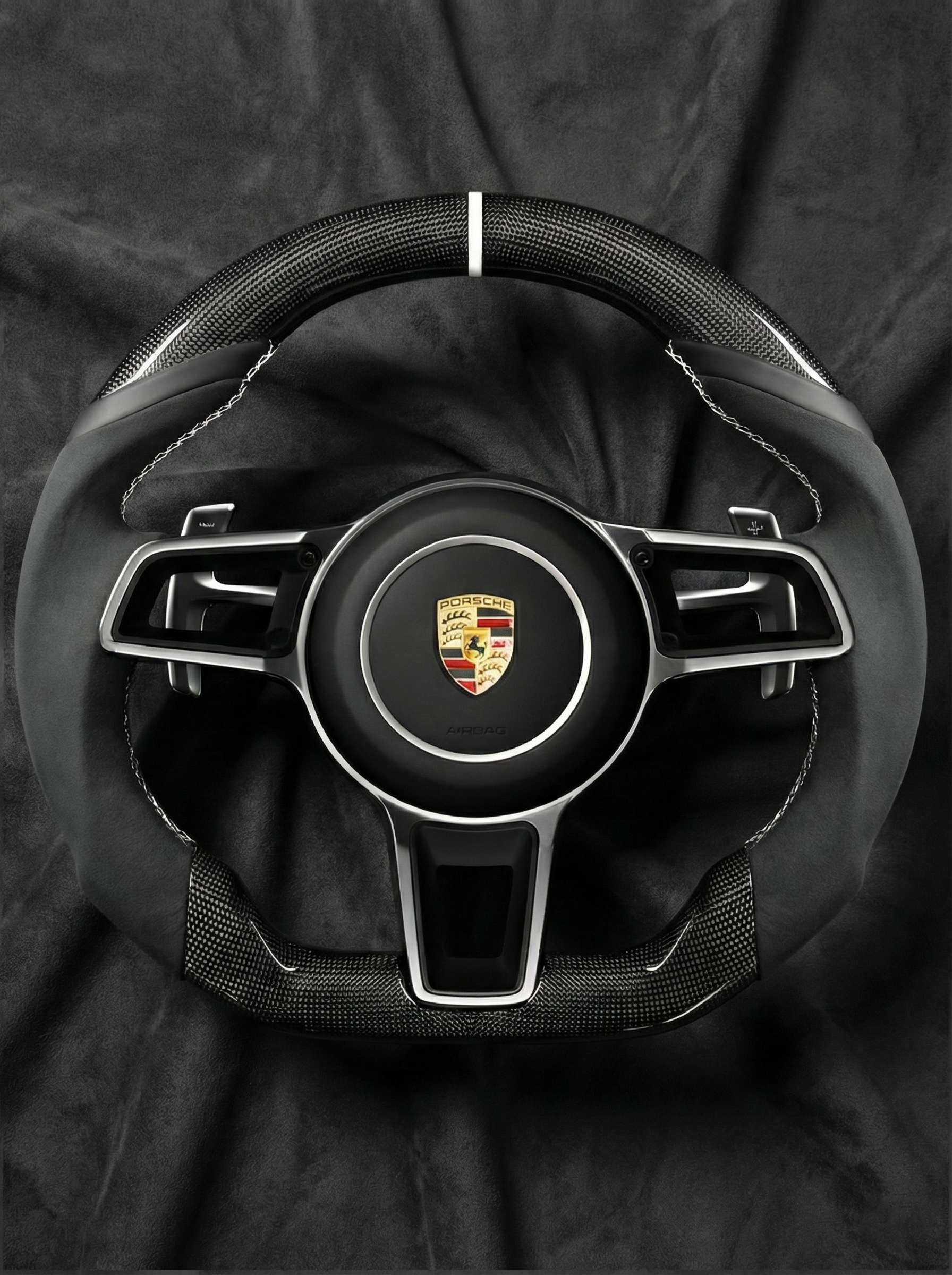 Steering wheel with Porsche logo on a black background