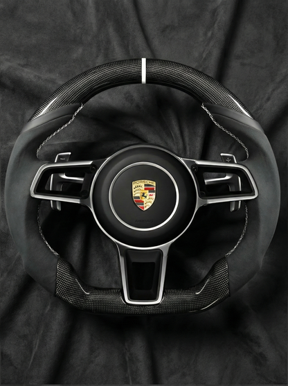 Steering wheel with Porsche logo on a black background
