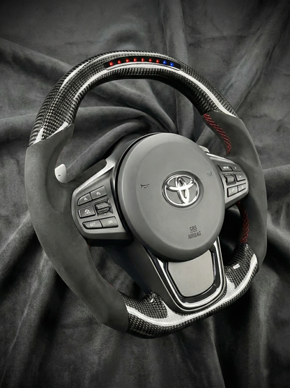 Car steering wheel with Toyota logo on a dark fabric background