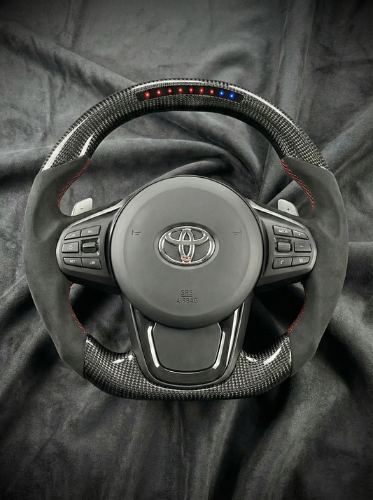 Car steering wheel with Toyota logo on a dark fabric background