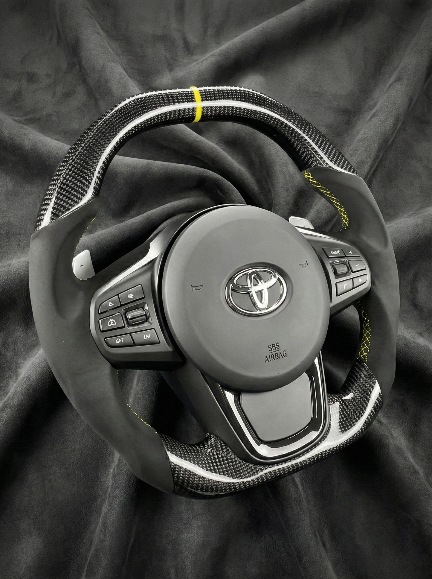 Steering wheel with Toyota logo on a dark fabric background