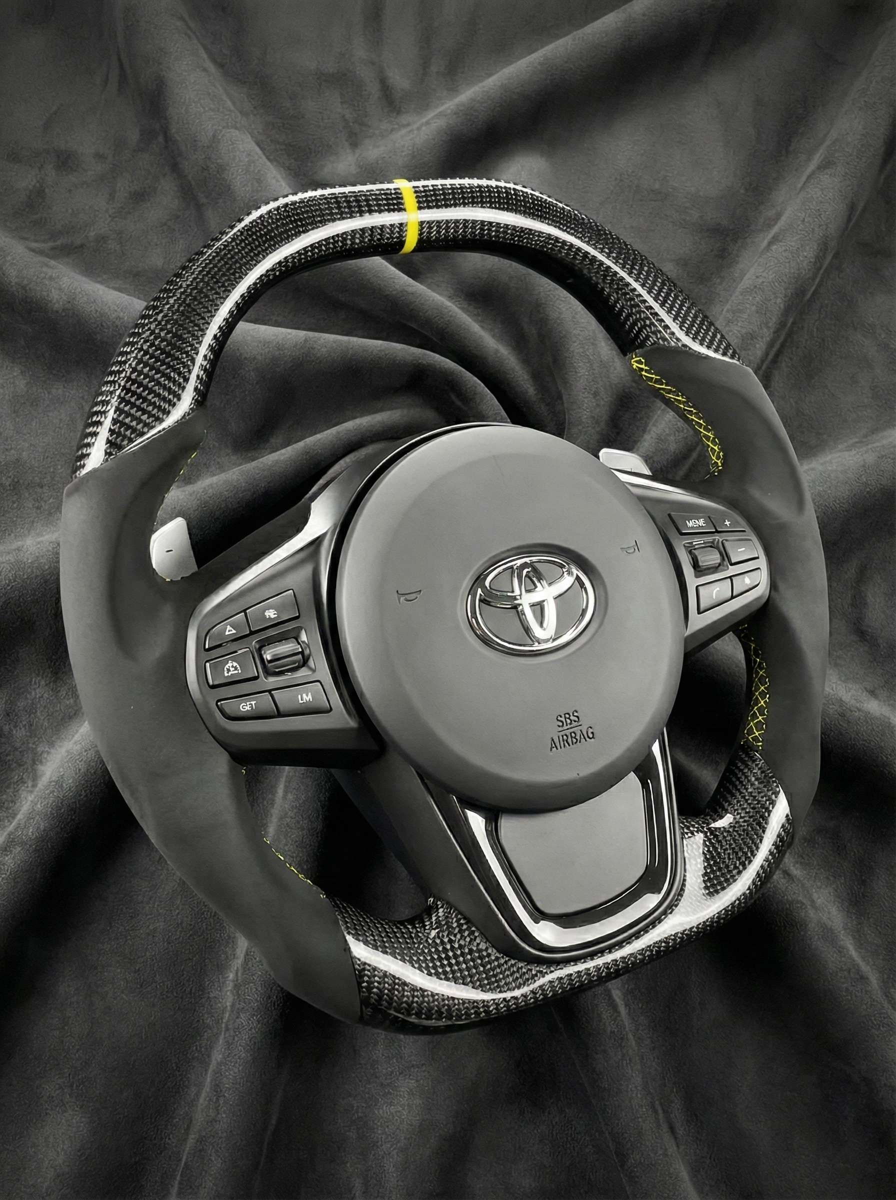 Steering wheel with Toyota logo on a dark fabric background