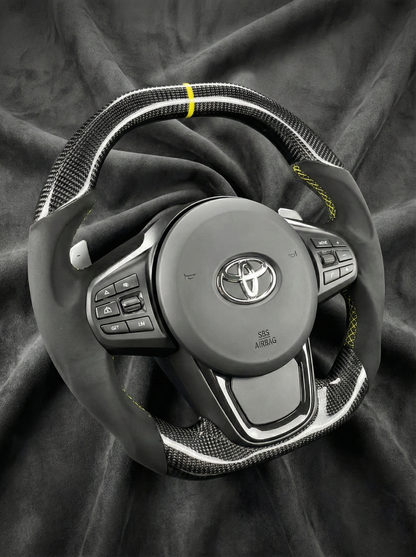 Steering wheel with Toyota logo on a dark fabric background