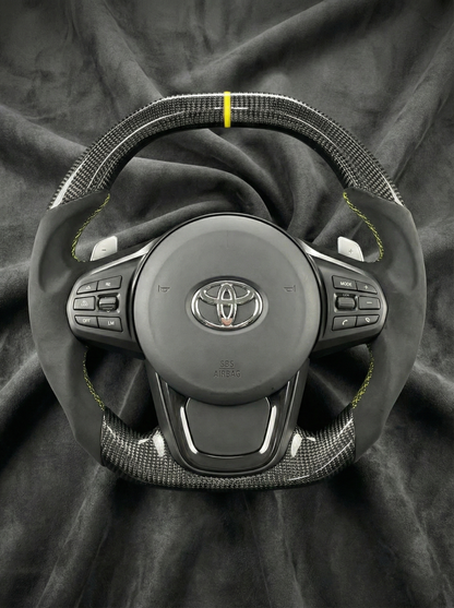 Car steering wheel with Toyota logo on a dark fabric background