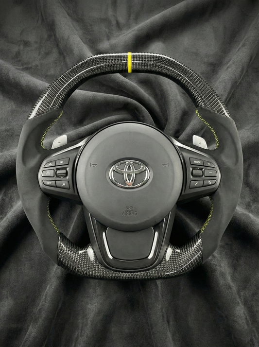 Car steering wheel with Toyota logo on a dark fabric background